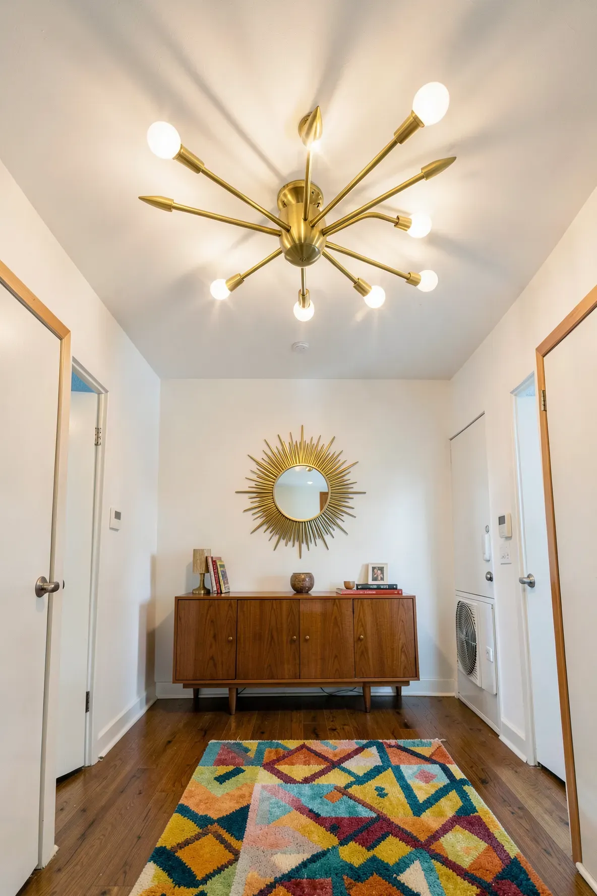 A brass Sputnik ceiling light with starburst arms in a mid-century modern entryway.