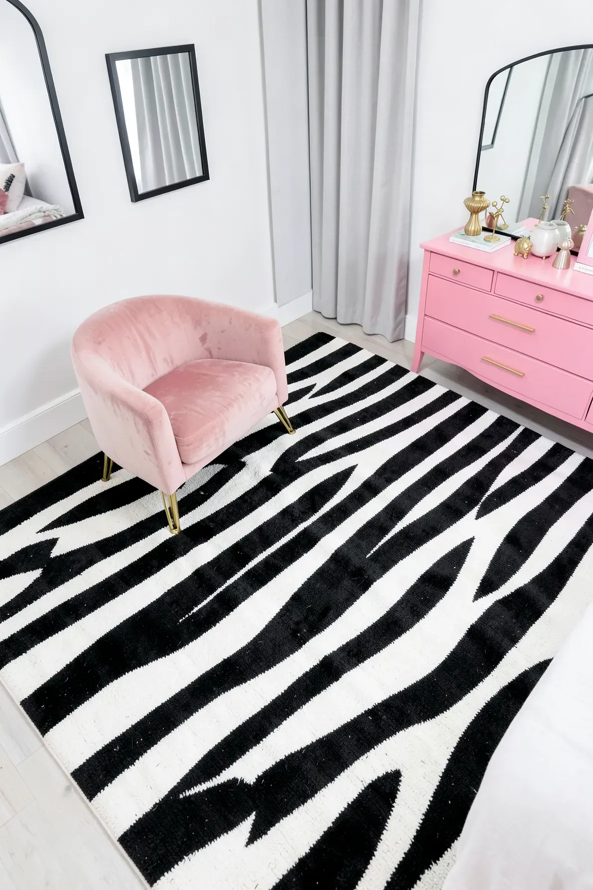 A bold black and white striped rug provides a graphic base for elegant pink furniture.