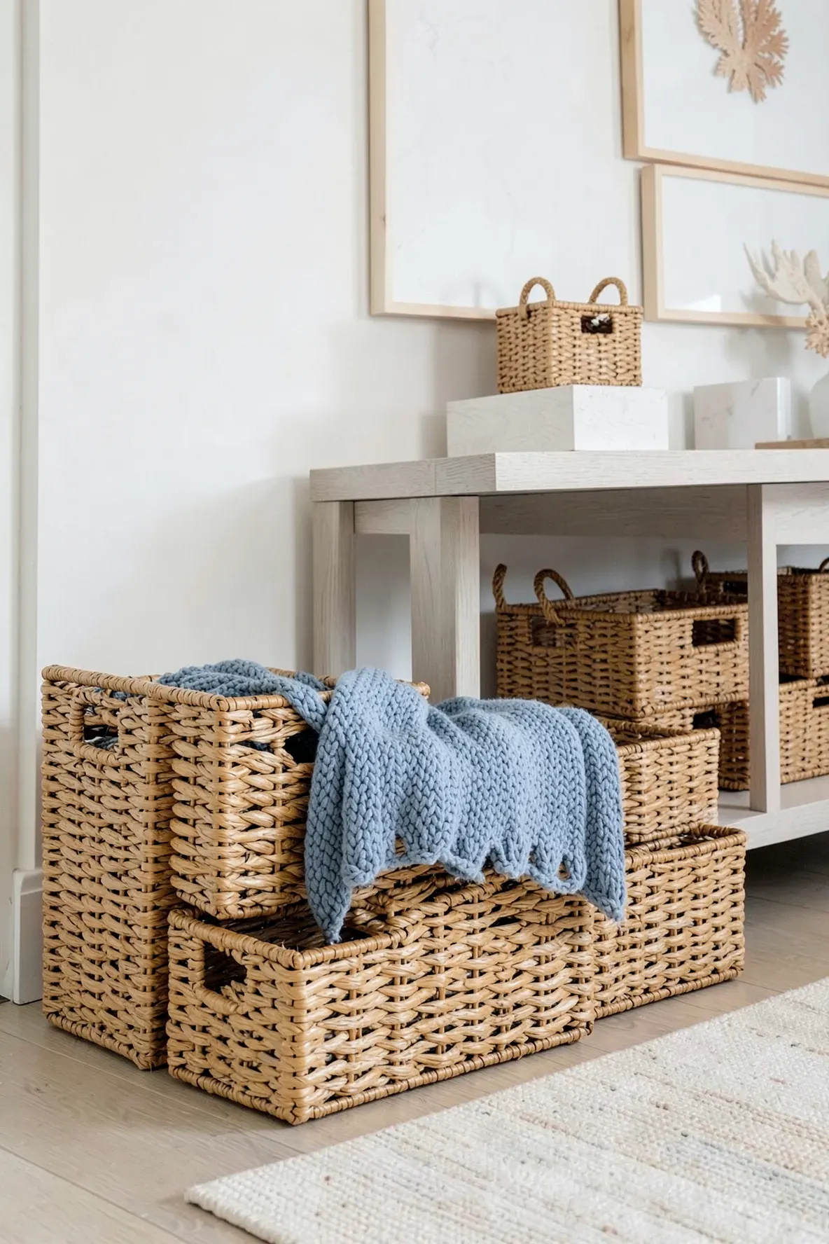 Natural honey-colored rattan storage baskets in a bright coastal room corner.