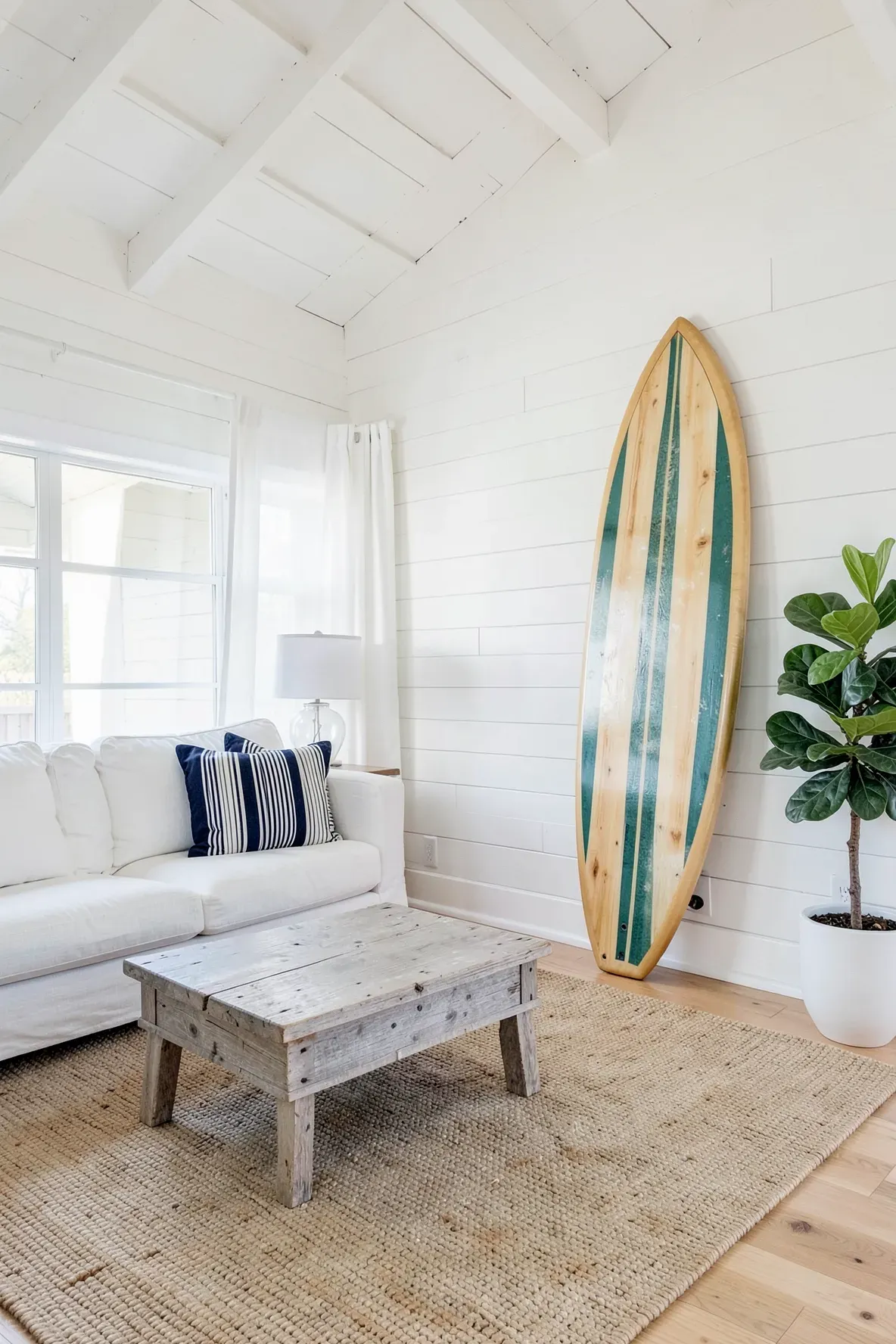 A stylish surfboard leaning against a white shiplap wall in a sunlit coastal living room.