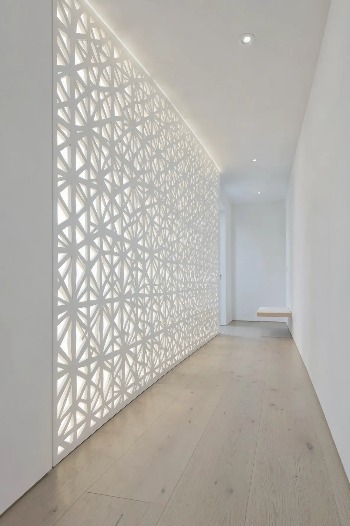 A modern hallway featuring a large decorative backlit wall panel that glows like a window.