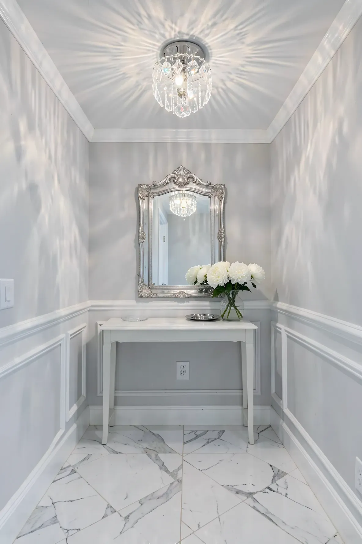 A sparkling crystal flush mount light fixture in a bright white and marble entryway.
