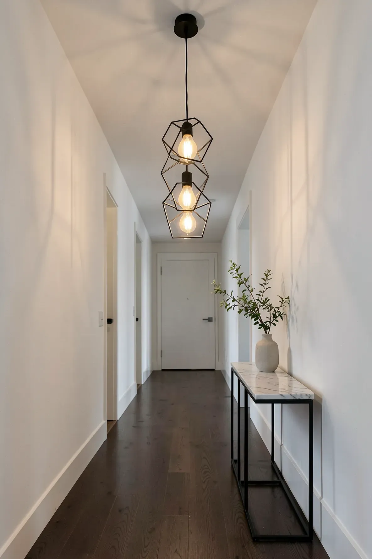 Three black hexagonal pendant lights hanging in a row down a long white modern hallway.