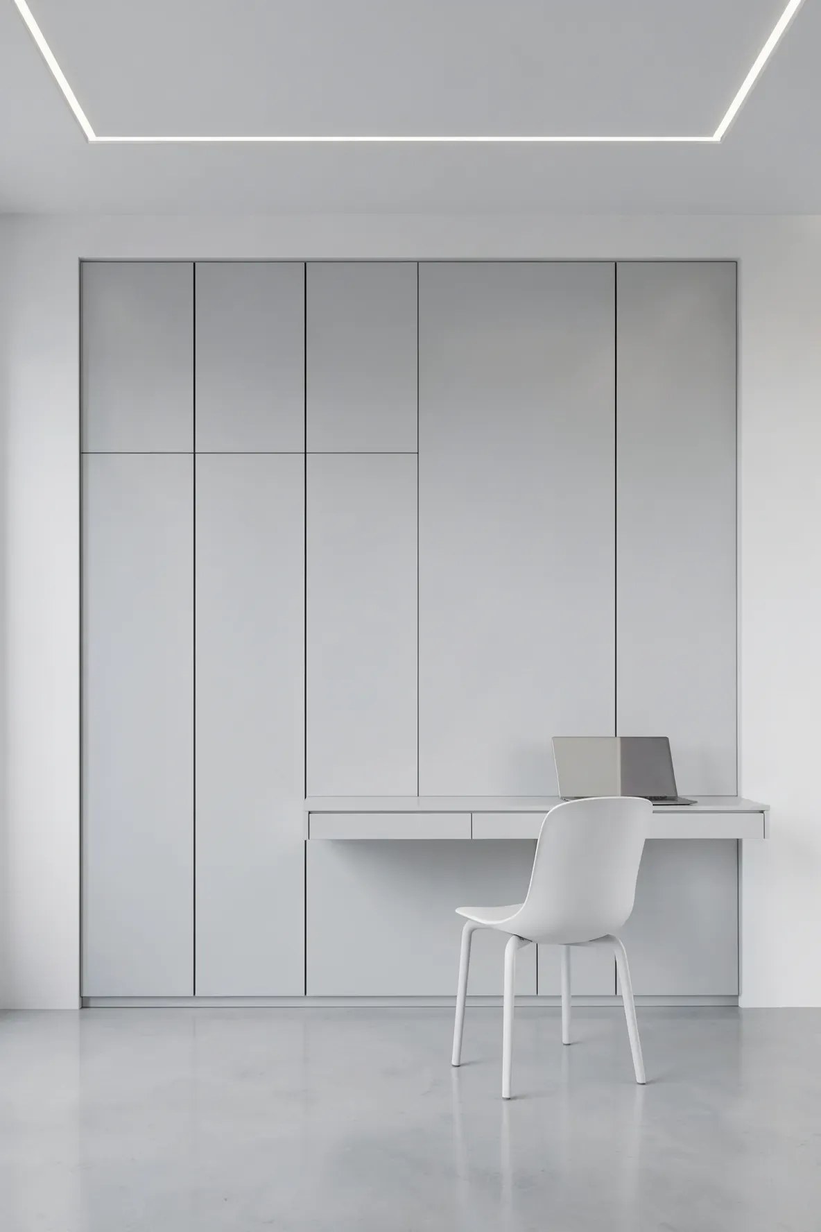 A seamless, handleless matte grey wardrobe with an integrated push-to-open desk in a modern room.