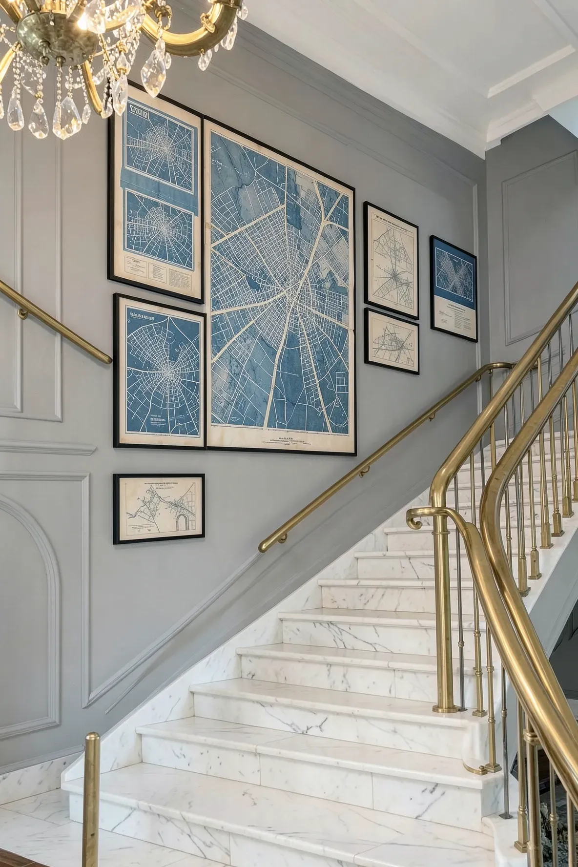 A grand staircase wall featuring large framed architectural blueprints and vintage city maps.