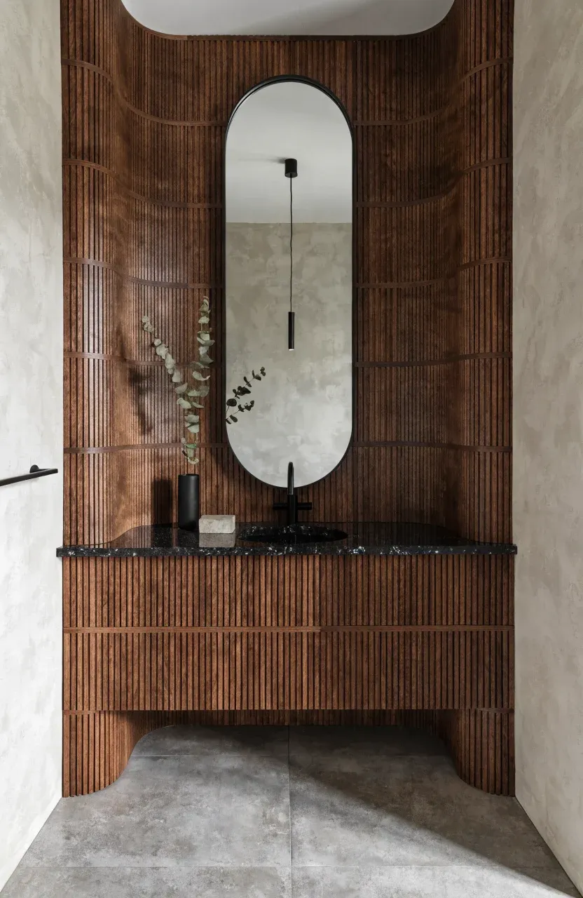 A modern walnut bathroom vanity with vertical slatted doors and a black quartz top.