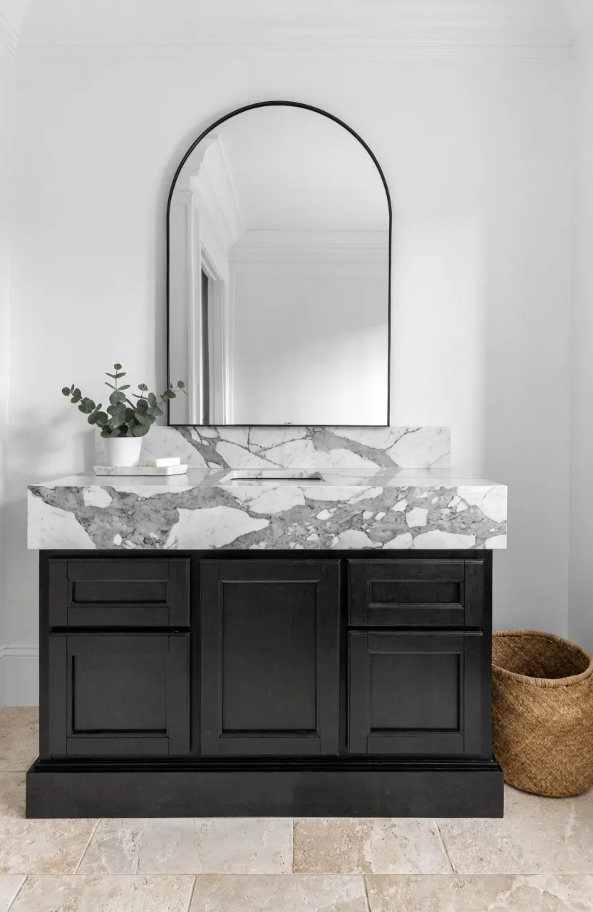 A black bathroom vanity topped with a white marble counter featuring grey veining.