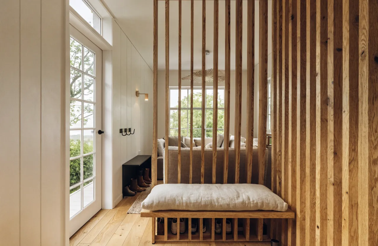 Tiny house entry zone with a light slatted divider marking the transition into the home