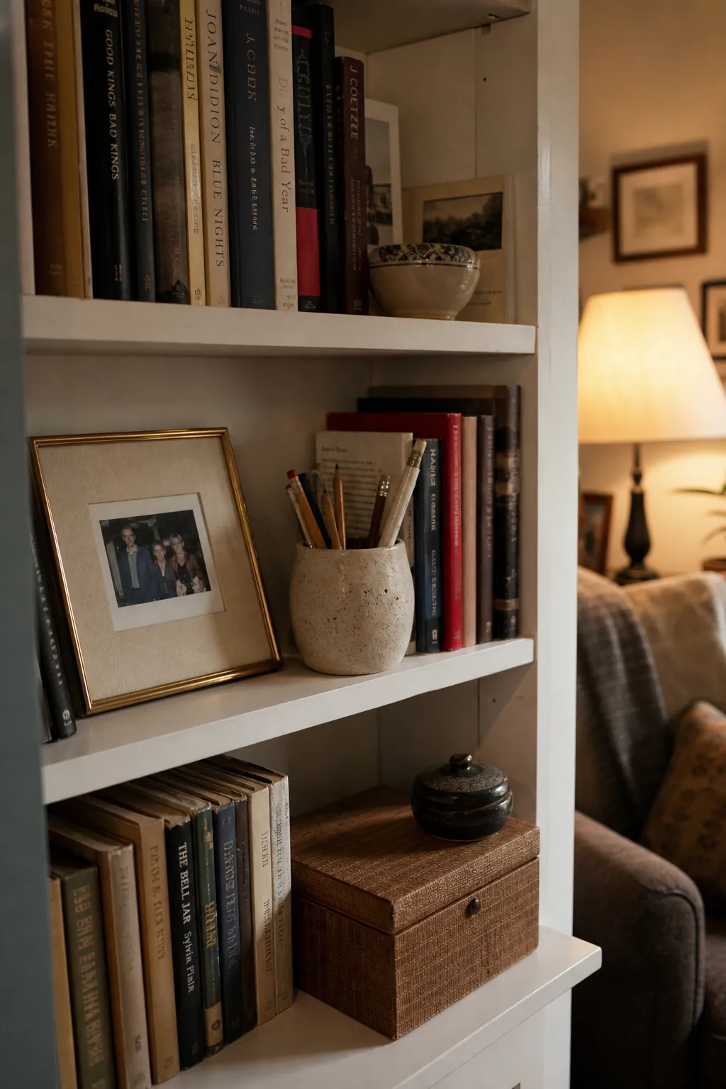 Personal bookshelf decor with framed photos, ceramics, and useful storage mixed among books