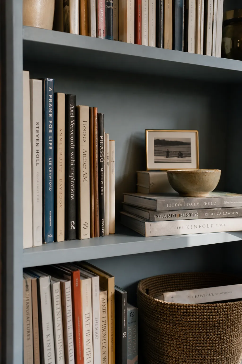 Asymmetrical shelf styling with uneven book stacks and natural gaps that feel lived in