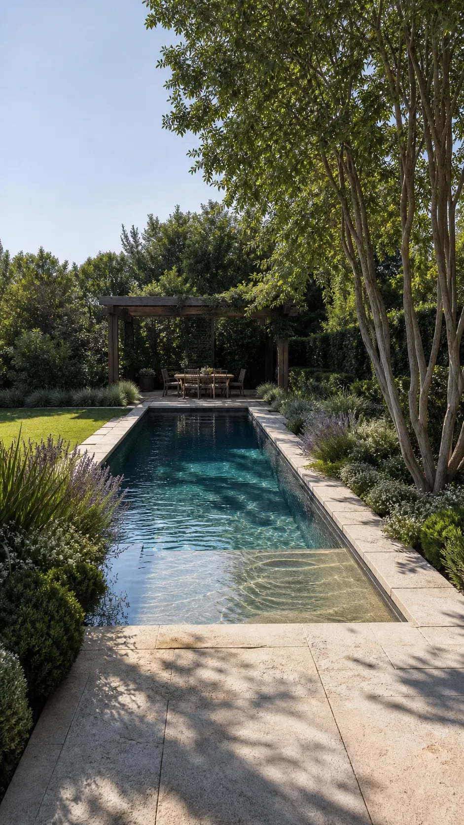 Beautiful garden pool design with layered planting, limestone terrace, and shaded pergola
