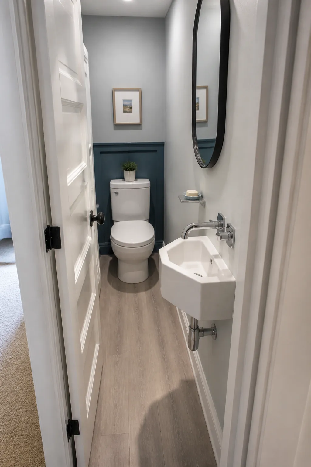 Narrow half bathroom with a corner sink that clears the door swing