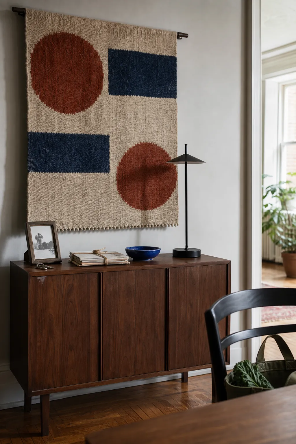 Inherited woven textile paired with a simple modern lamp and personal objects