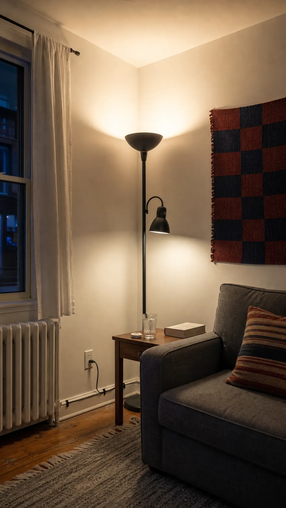 Tall floor lamp bouncing light from the ceiling in a small rental living room