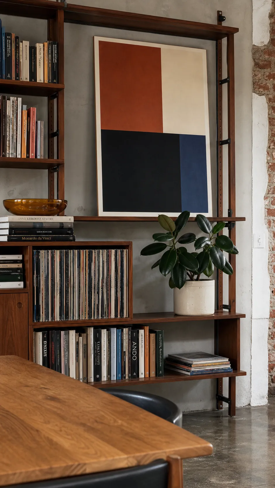 Bookshelf styling with varied art scale, book blocks, and one sculptural plant