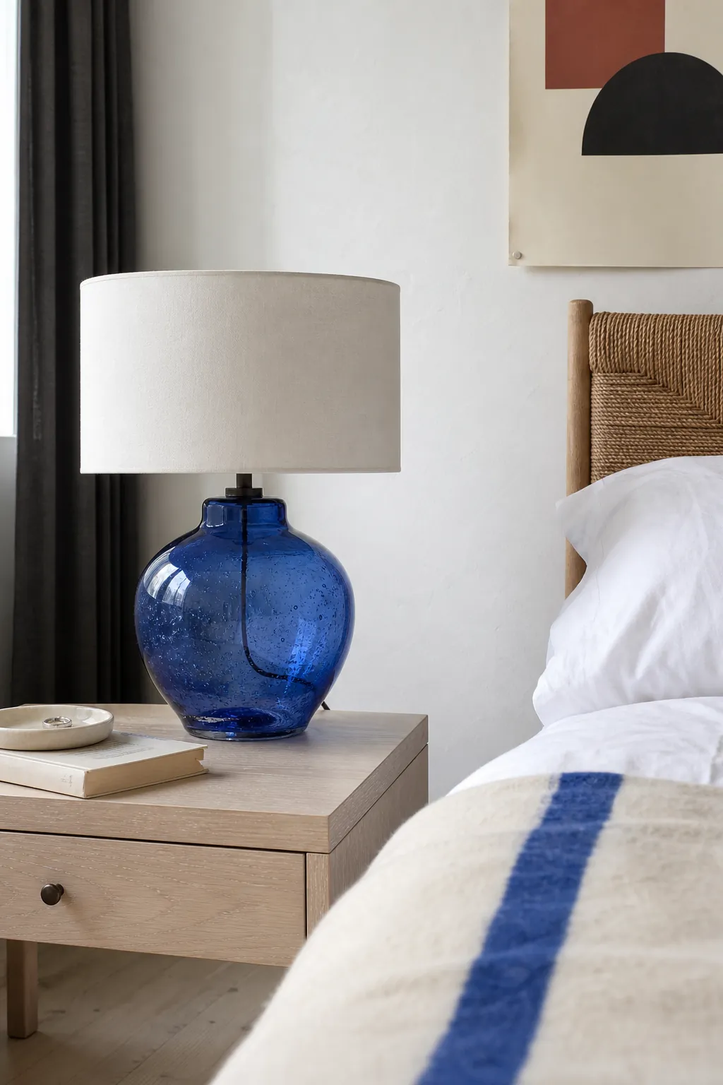Sculptural colored table lamp on a simple uncluttered nightstand