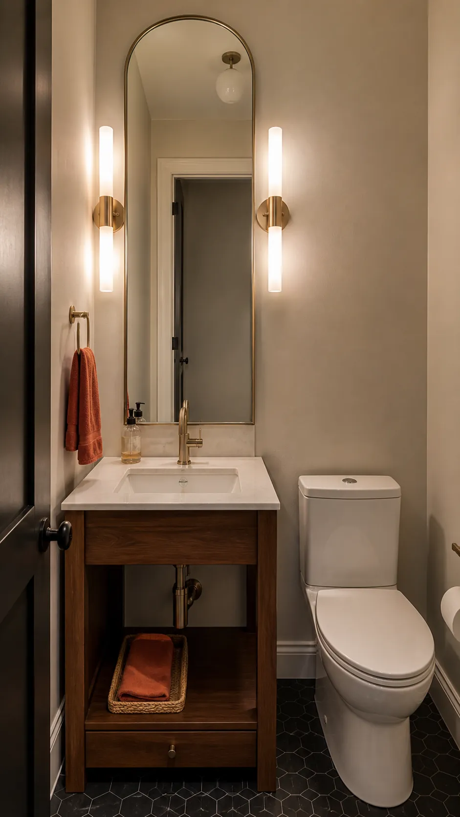 Tall mirror with soft lighting in a windowless tiny half bath