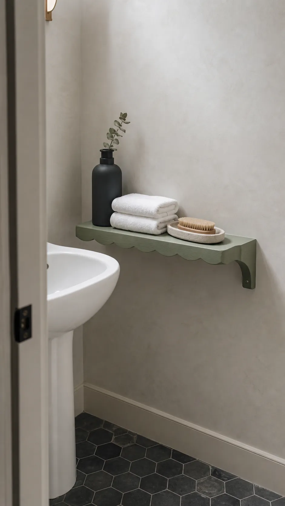 Three small decorative objects arranged at varied heights on a scalloped shelf
