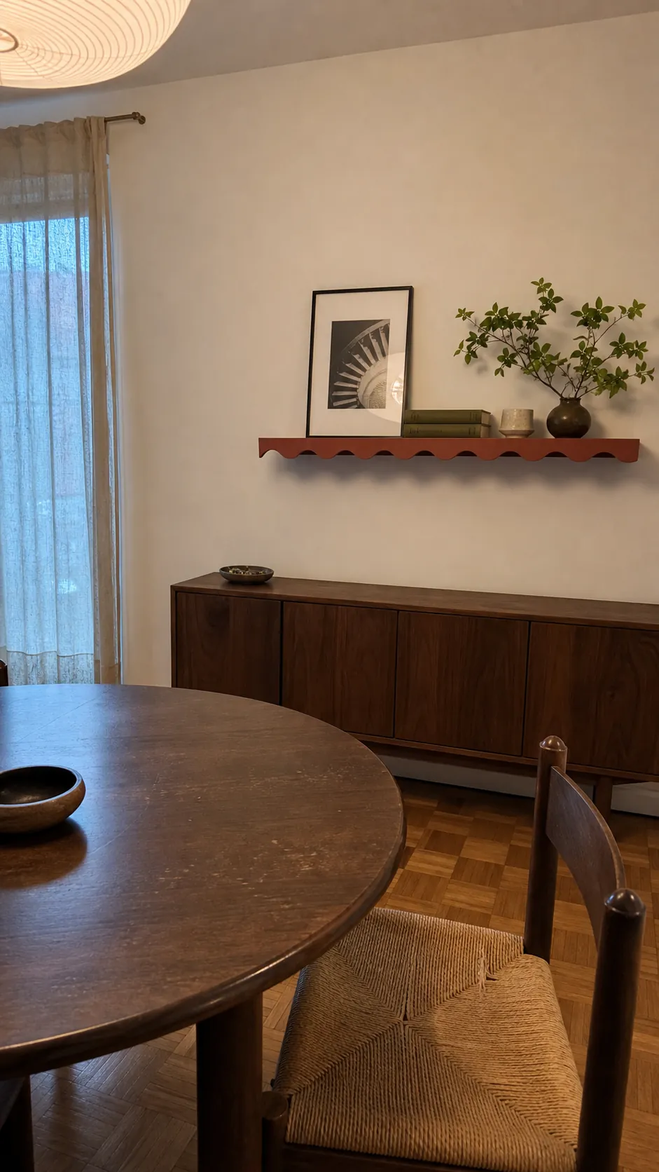 Edited scalloped shelf viewed from across a warm dining room