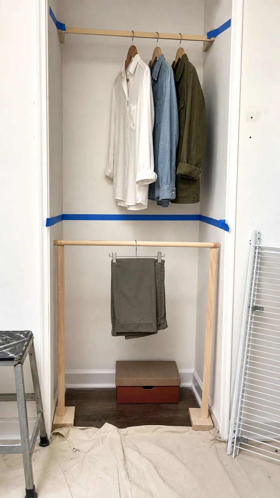 Painter tape marking upper and lower closet rod heights beside hanging shirts