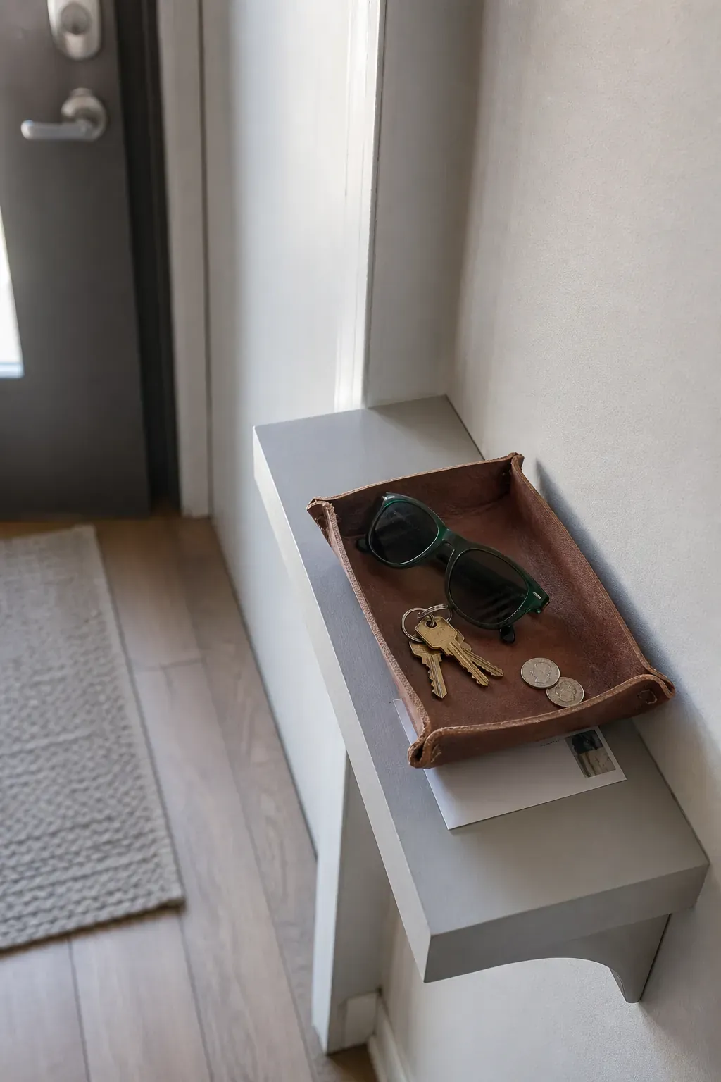 Small catchall tray organizing keys in a narrow entryway