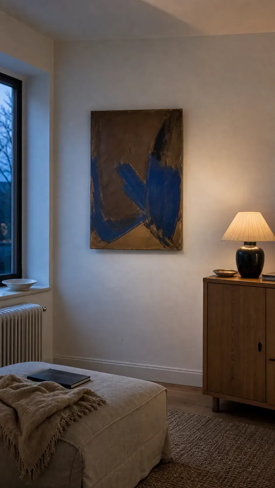Calm collected living room with one meaningful painting and intentional blank wall space