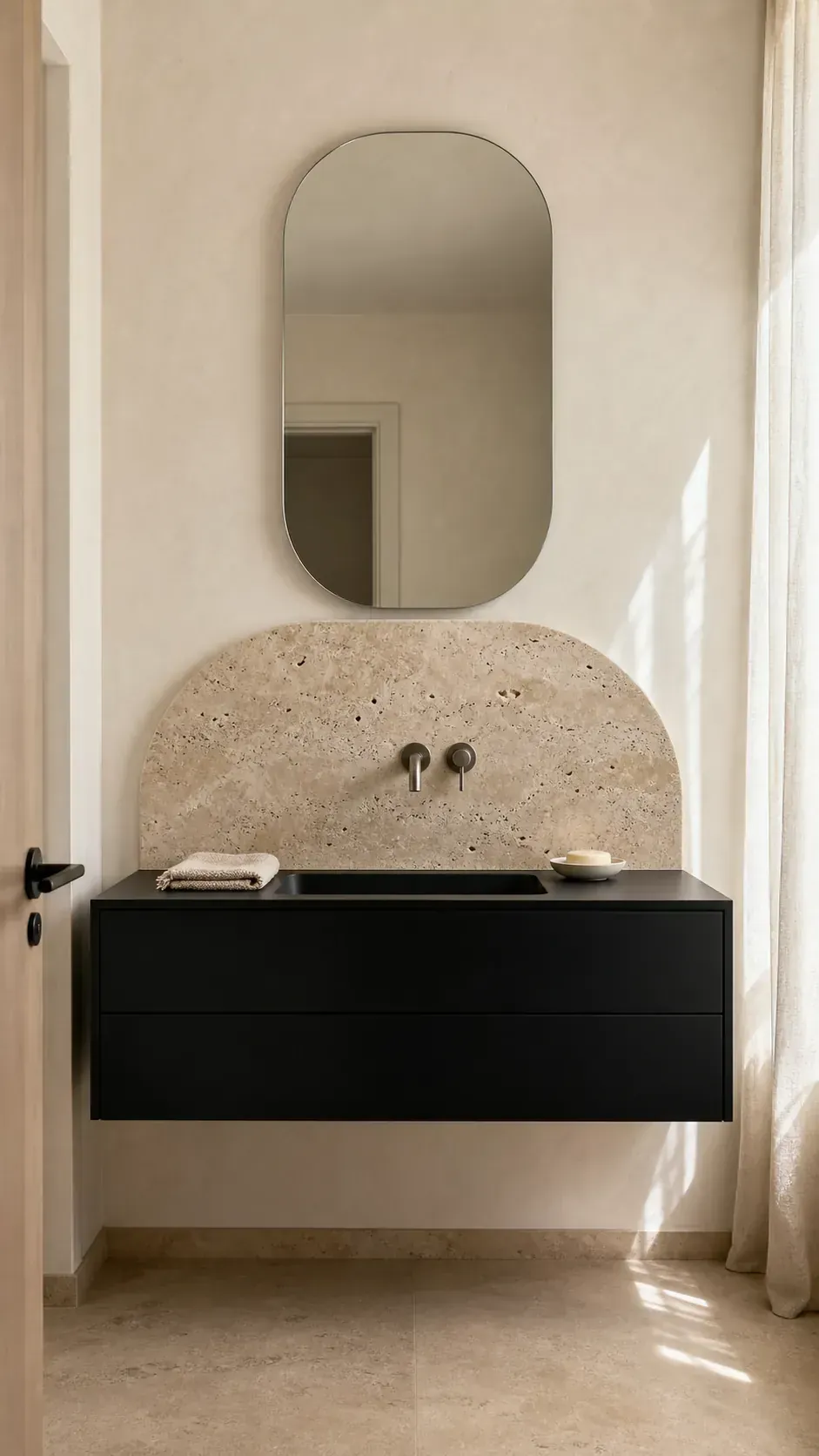 Black bathroom vanity with rounded warm travertine backsplash