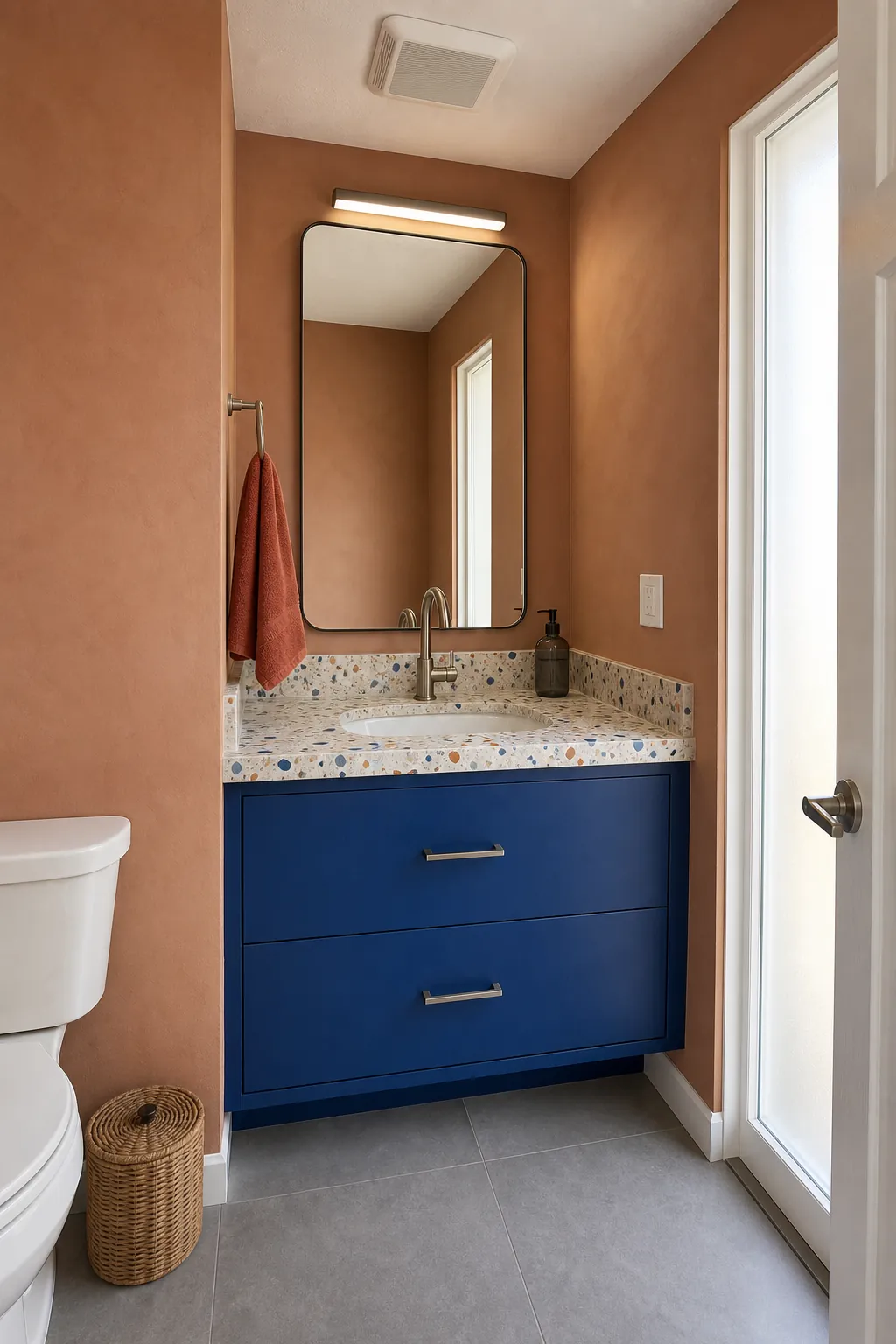 Fun guest bathroom with terrazzo surfaces and a bright cobalt vanity