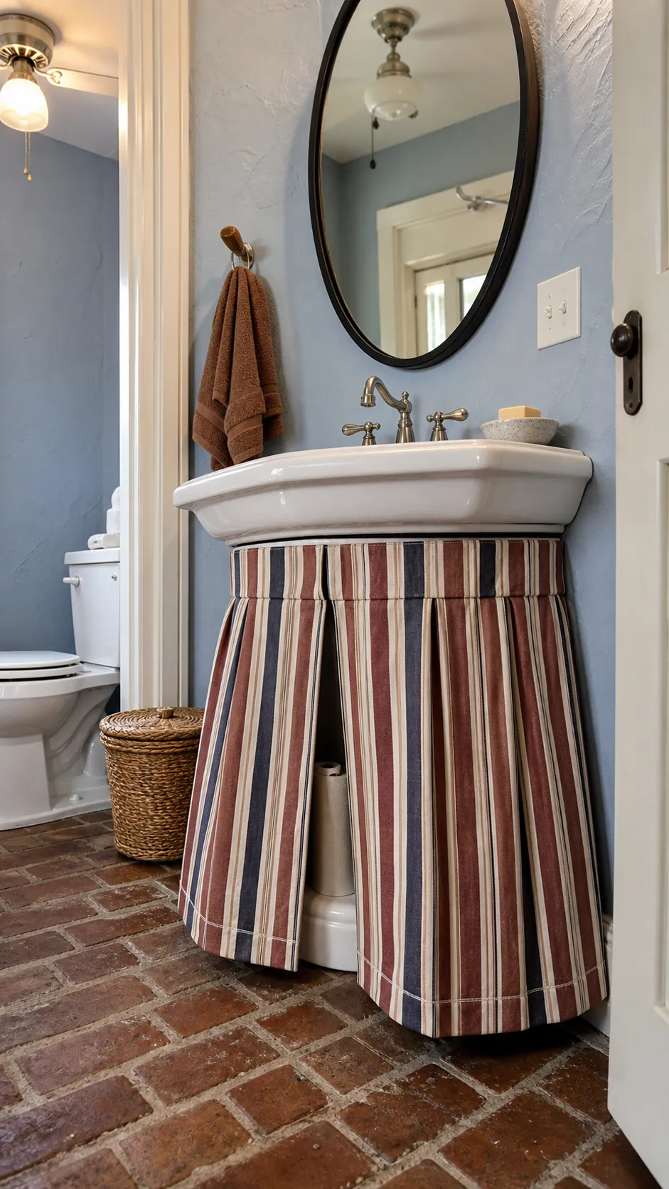 Pedestal sink with a tailored striped fabric skirt for concealed storage