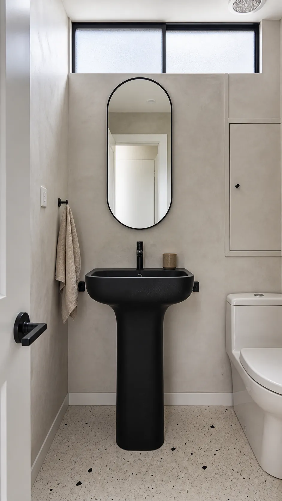 Modern black pedestal sink in a light minimalist half bathroom
