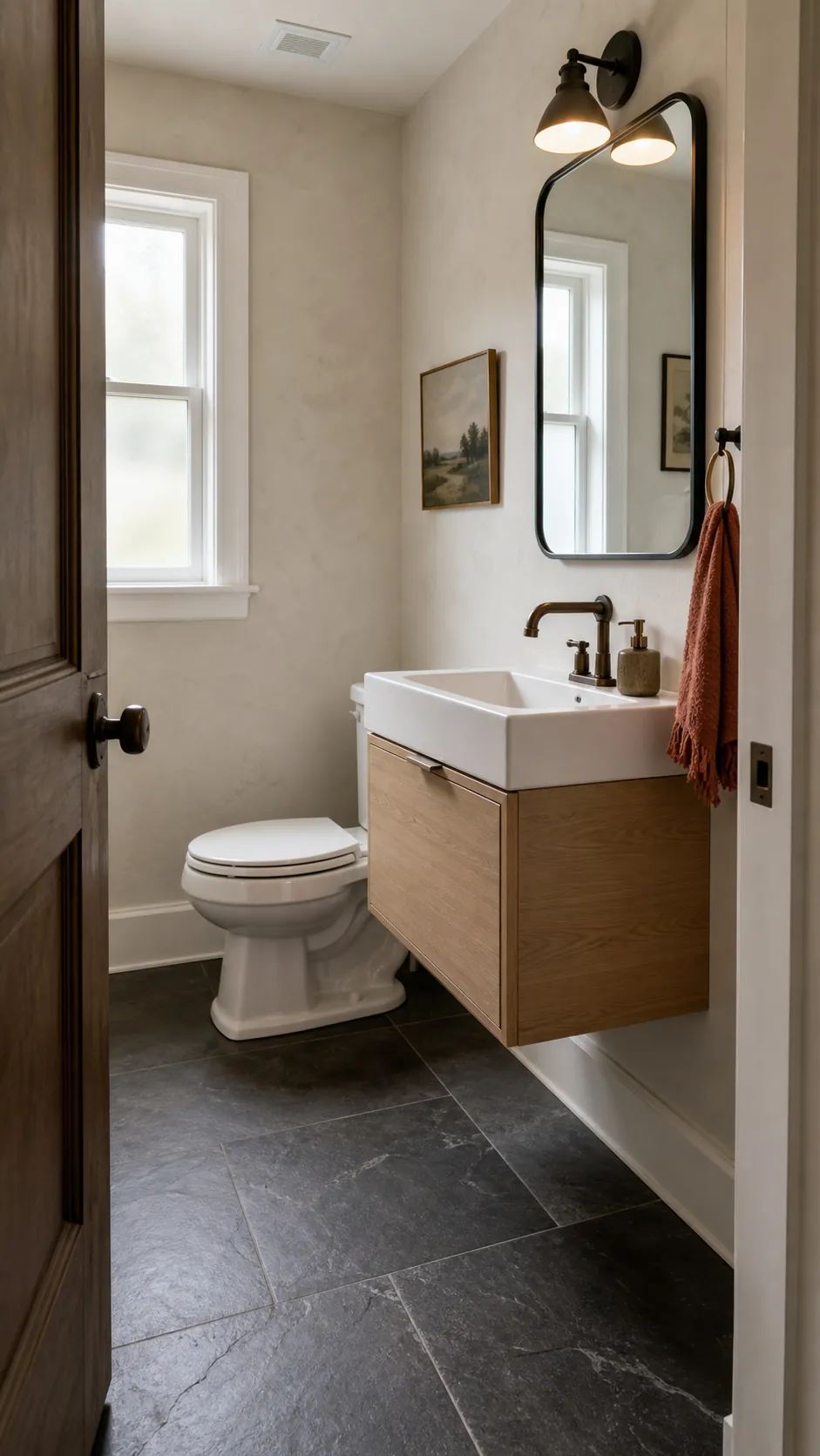 Small rustic half bathroom with charcoal slate floor tile and warm wood accents