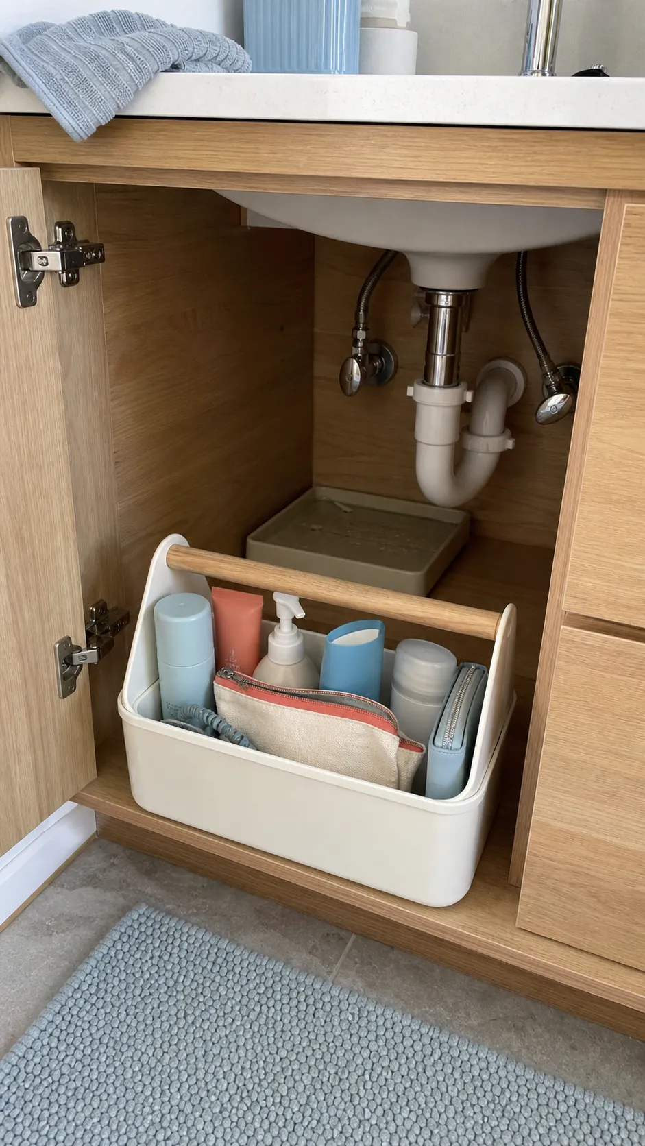 Handled morning routine caddy stored neatly inside a bathroom vanity