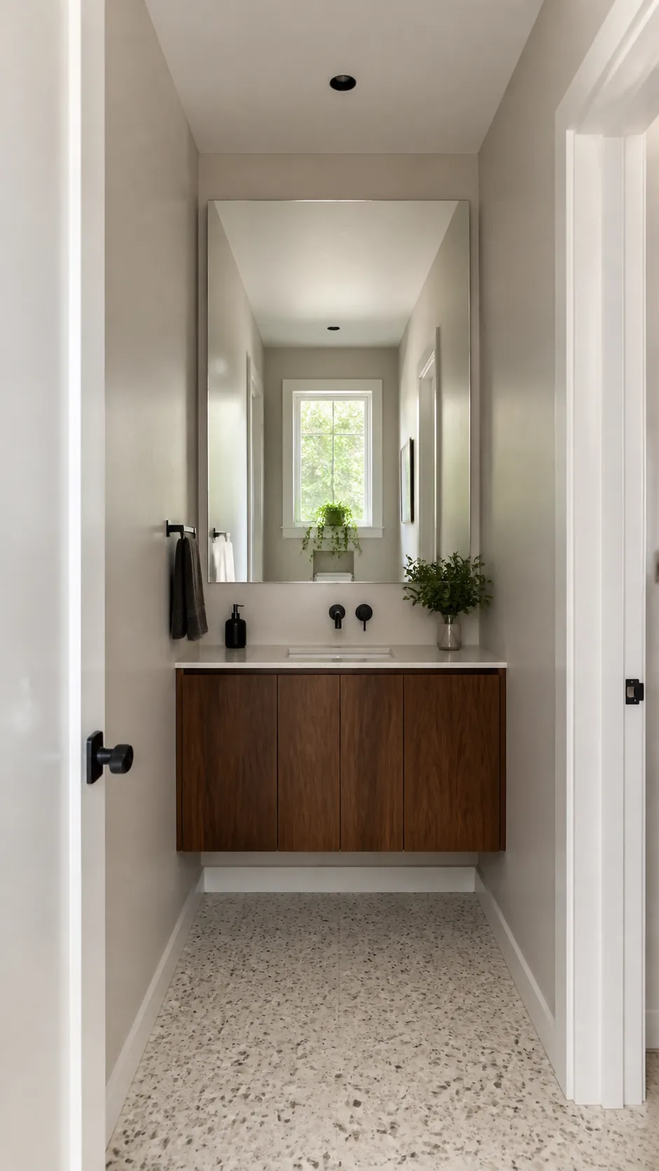 Wide mirror visually enlarging a narrow bathroom vanity wall