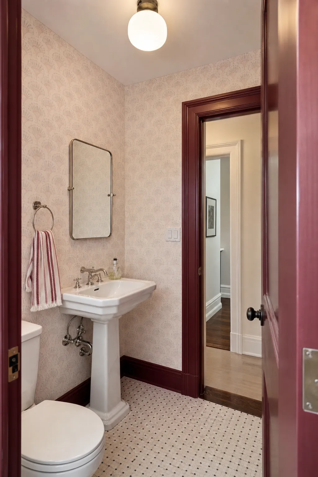 Elegant powder room with burgundy trim and pale patterned walls