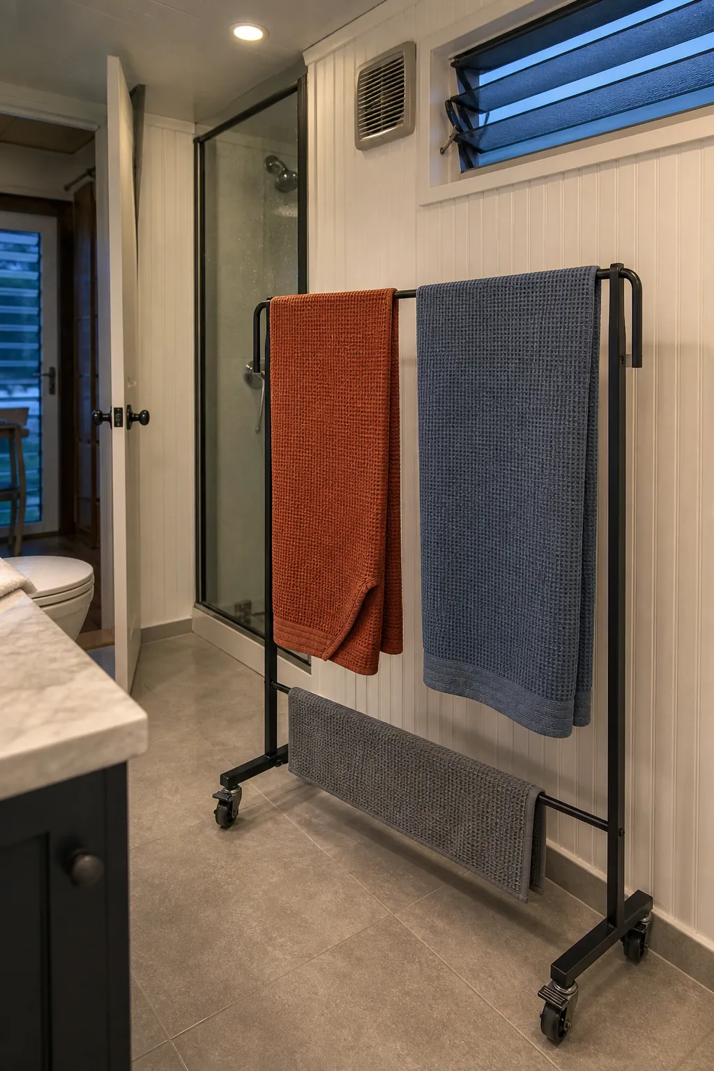 Tiny house bathroom with two towels spread separately on a ventilated drying rail