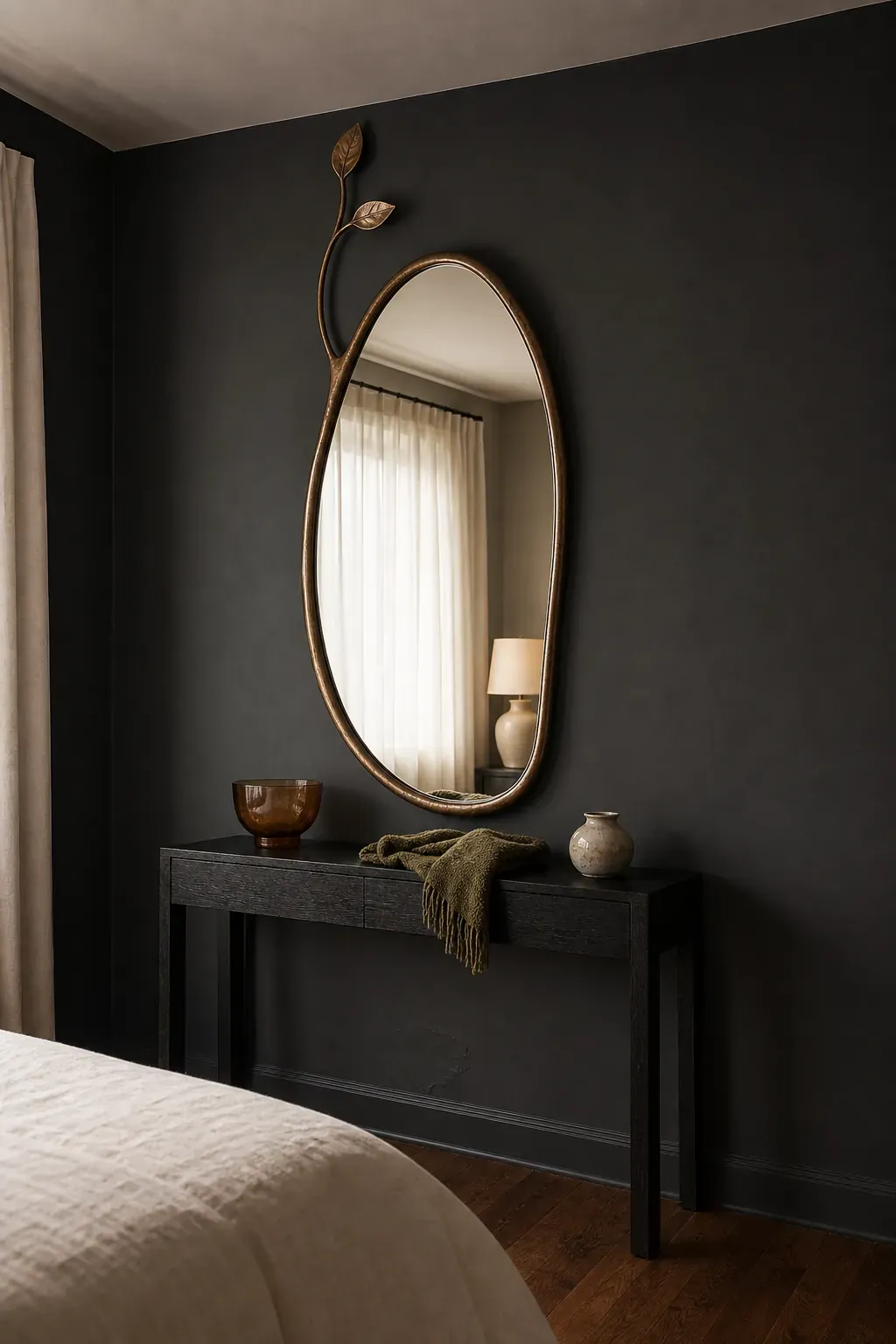 Asymmetrical bronze-framed mirror reflecting soft bedroom light