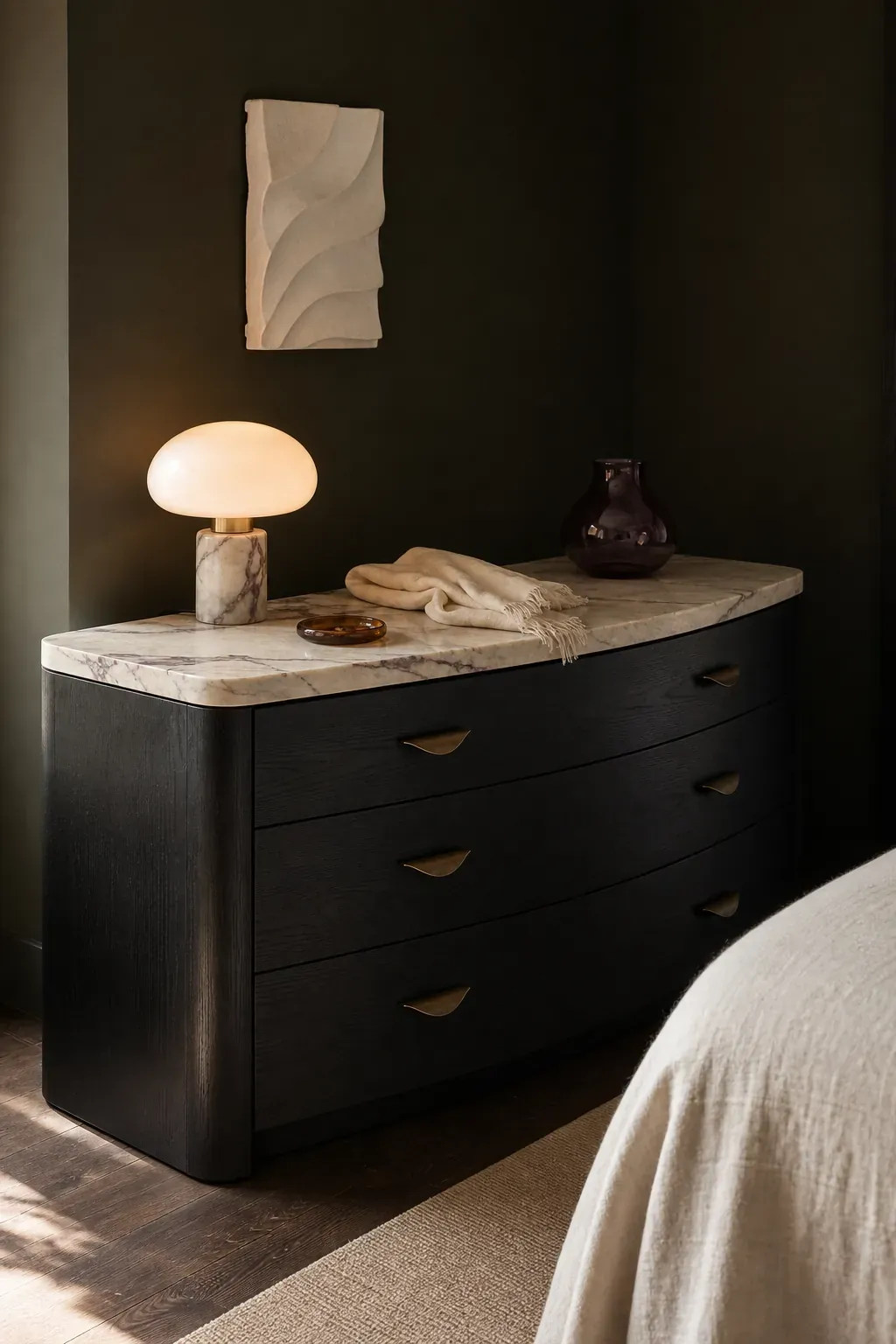 Black curved dresser topped with pale veined marble