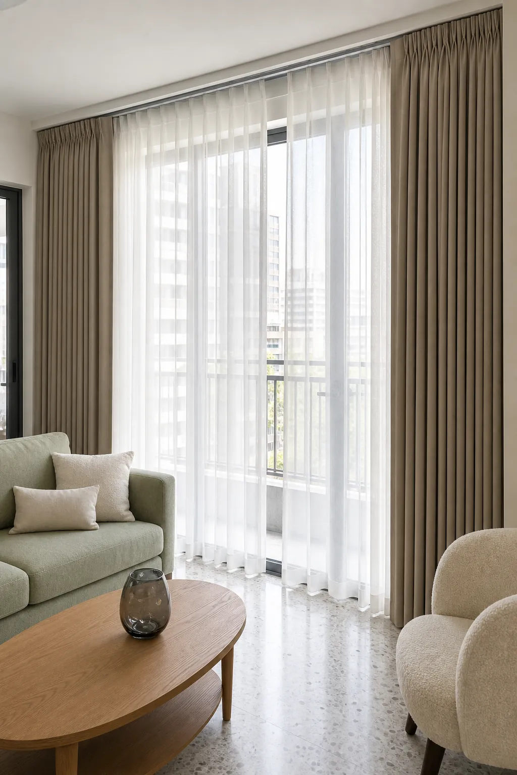 Layered sheers and pinch-pleat drapes hanging full length in a living room