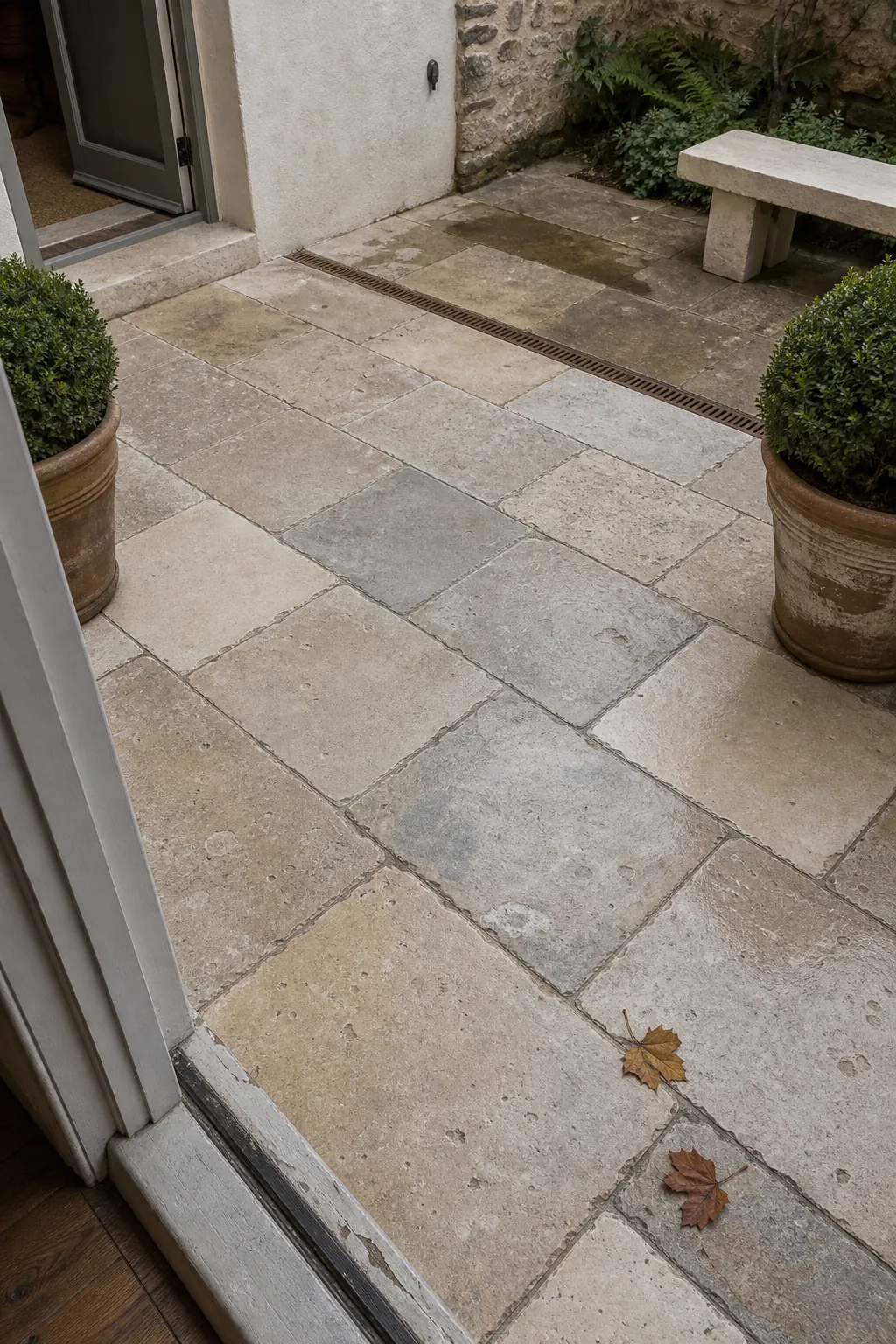 Reclaimed limestone paving in a softly weathered European courtyard