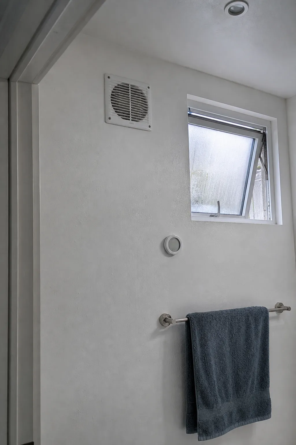 Compact bathroom with a clear exhaust fan and uncluttered ventilation path