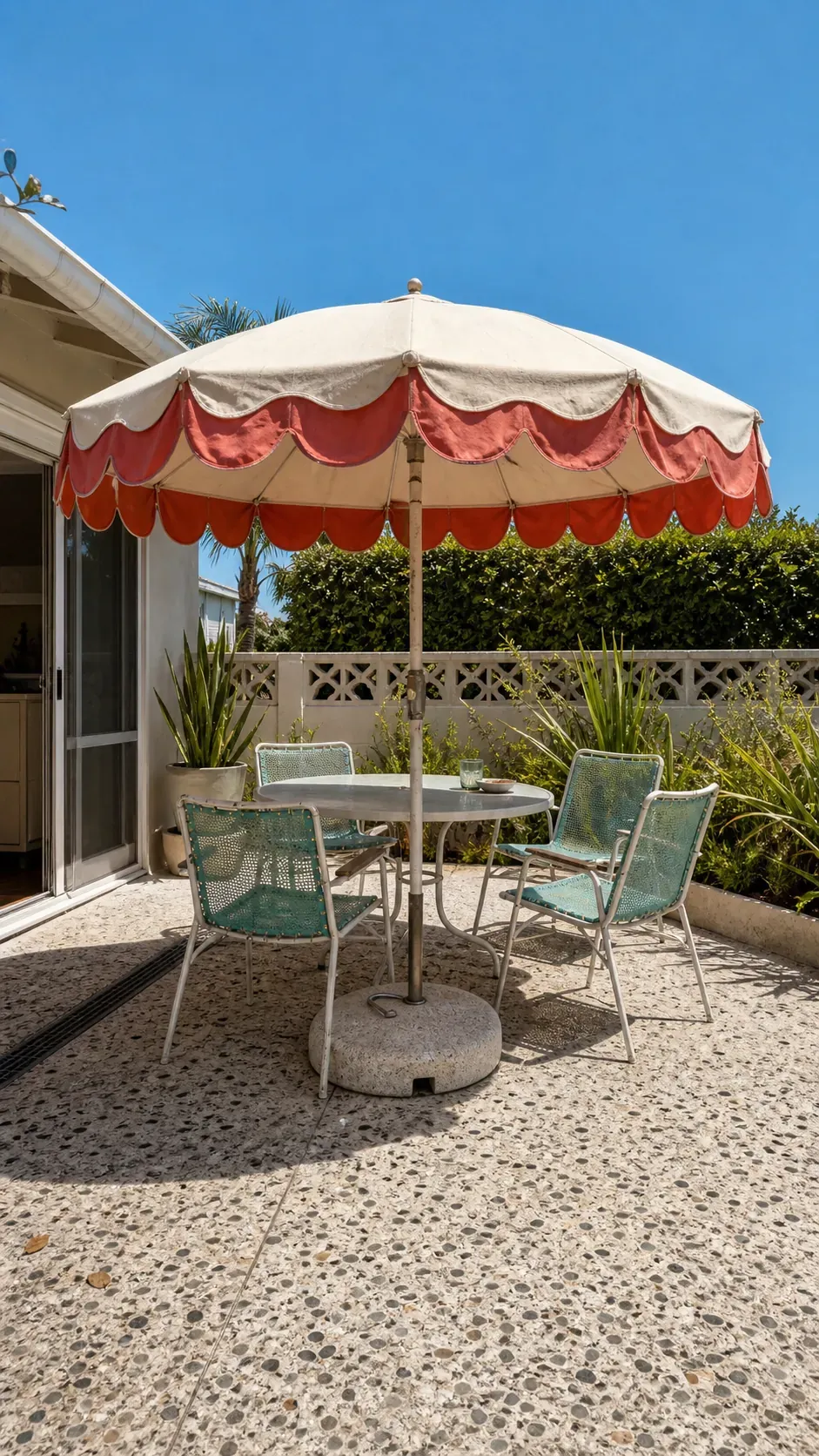 Scalloped striped market umbrella shading a vintage patio table