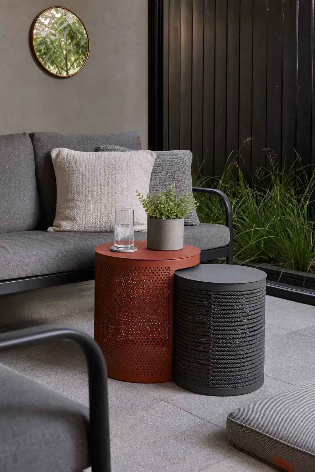 Nesting outdoor stools used as compact side tables beside patio seating
