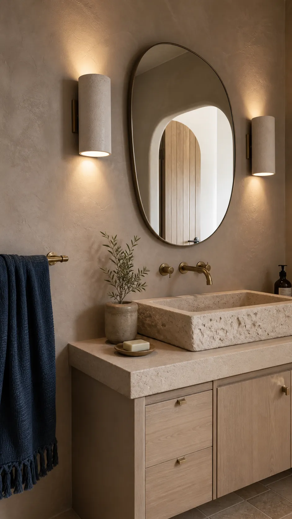 Sculptural Plaster Sconces on a Textured Wall beside a bathroom mirror