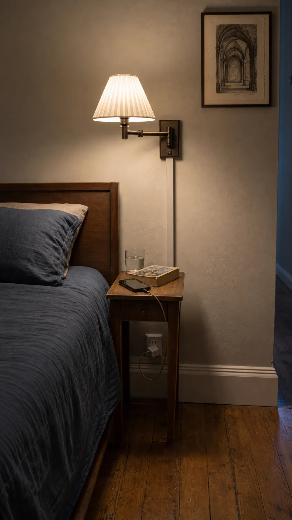 Plug-in bedroom sconce above a compact nightstand