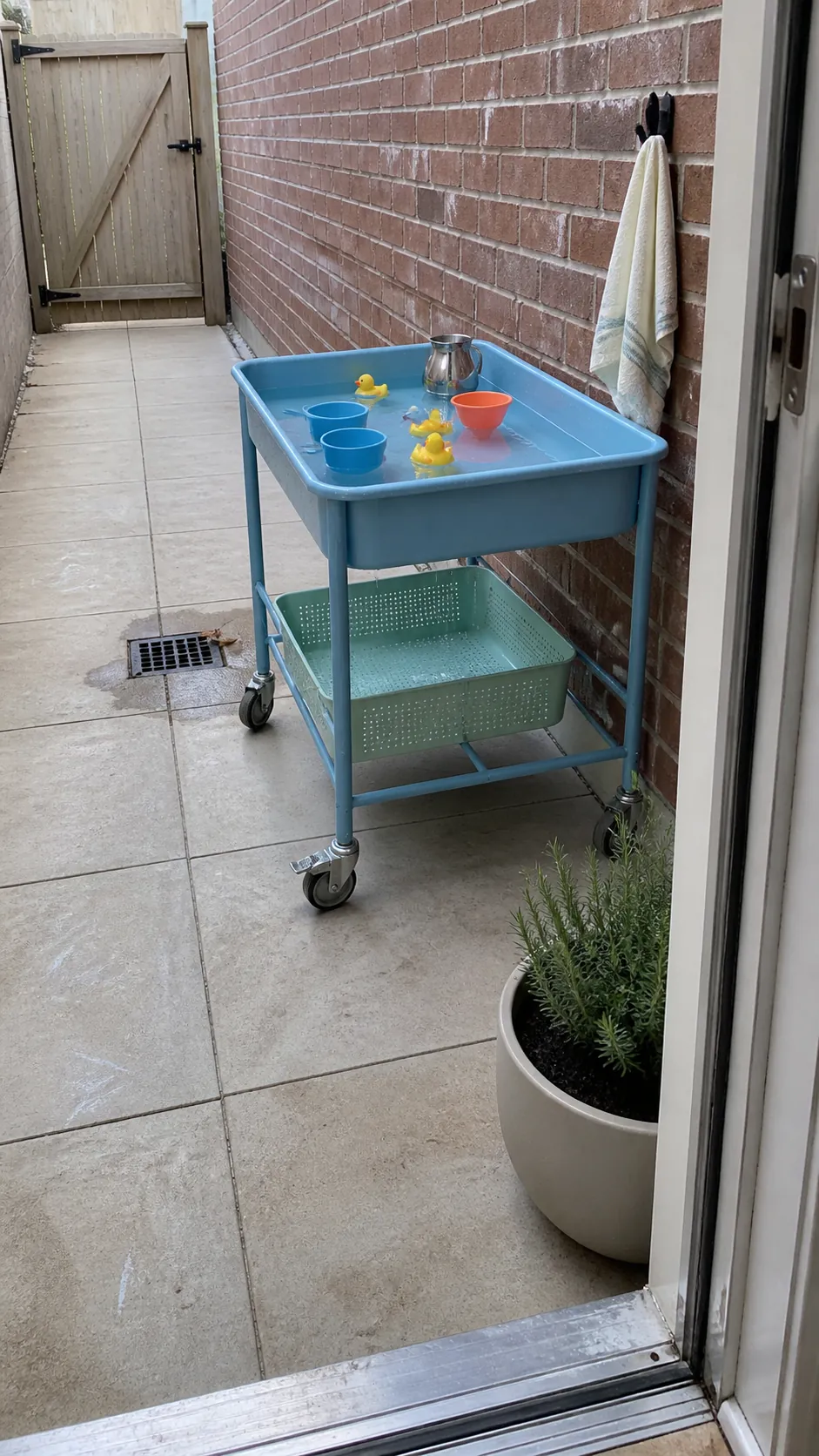 Compact rolling water table on a small kid-friendly patio