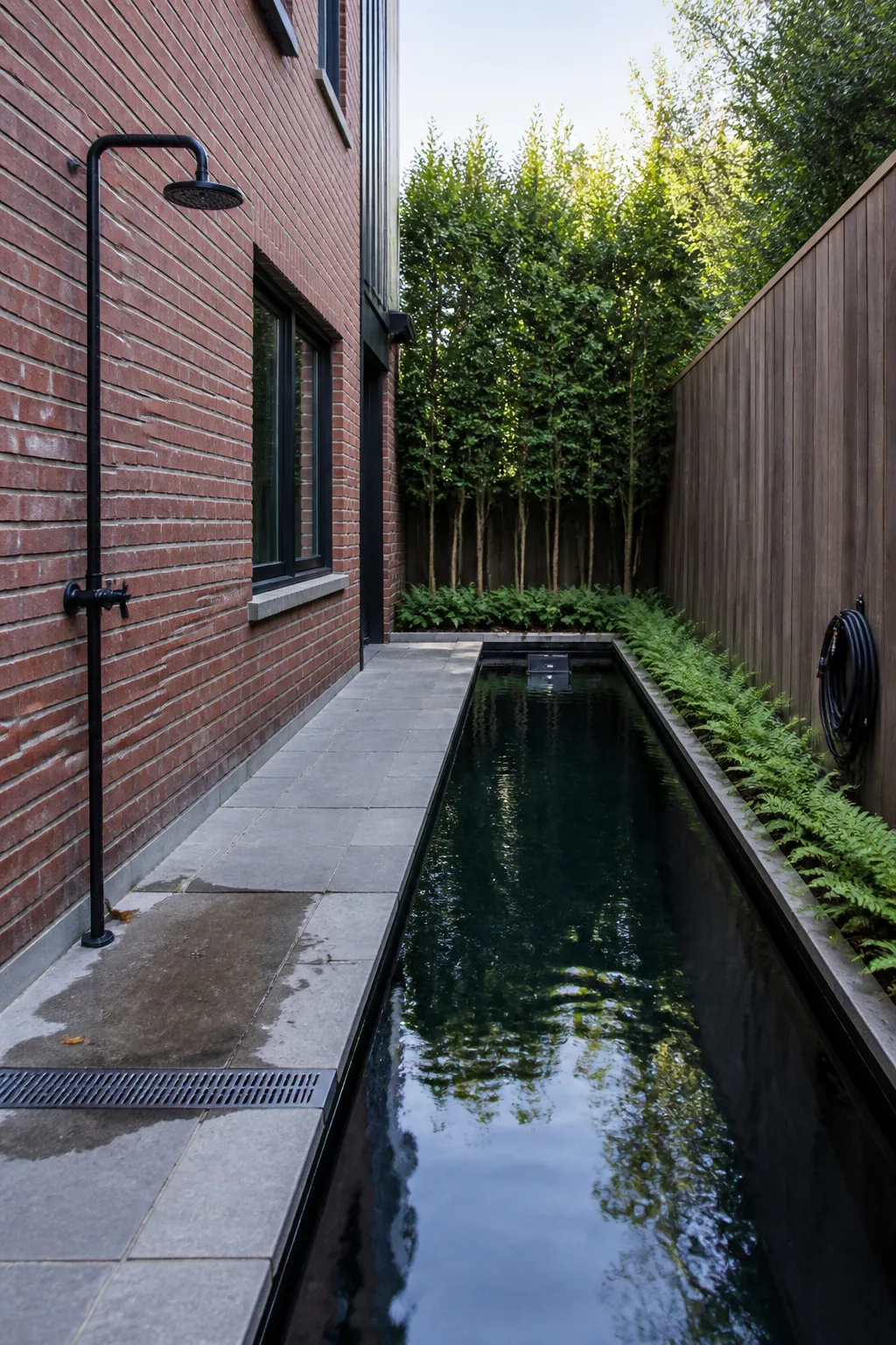 Narrow natural lap pond fitted into a side garden