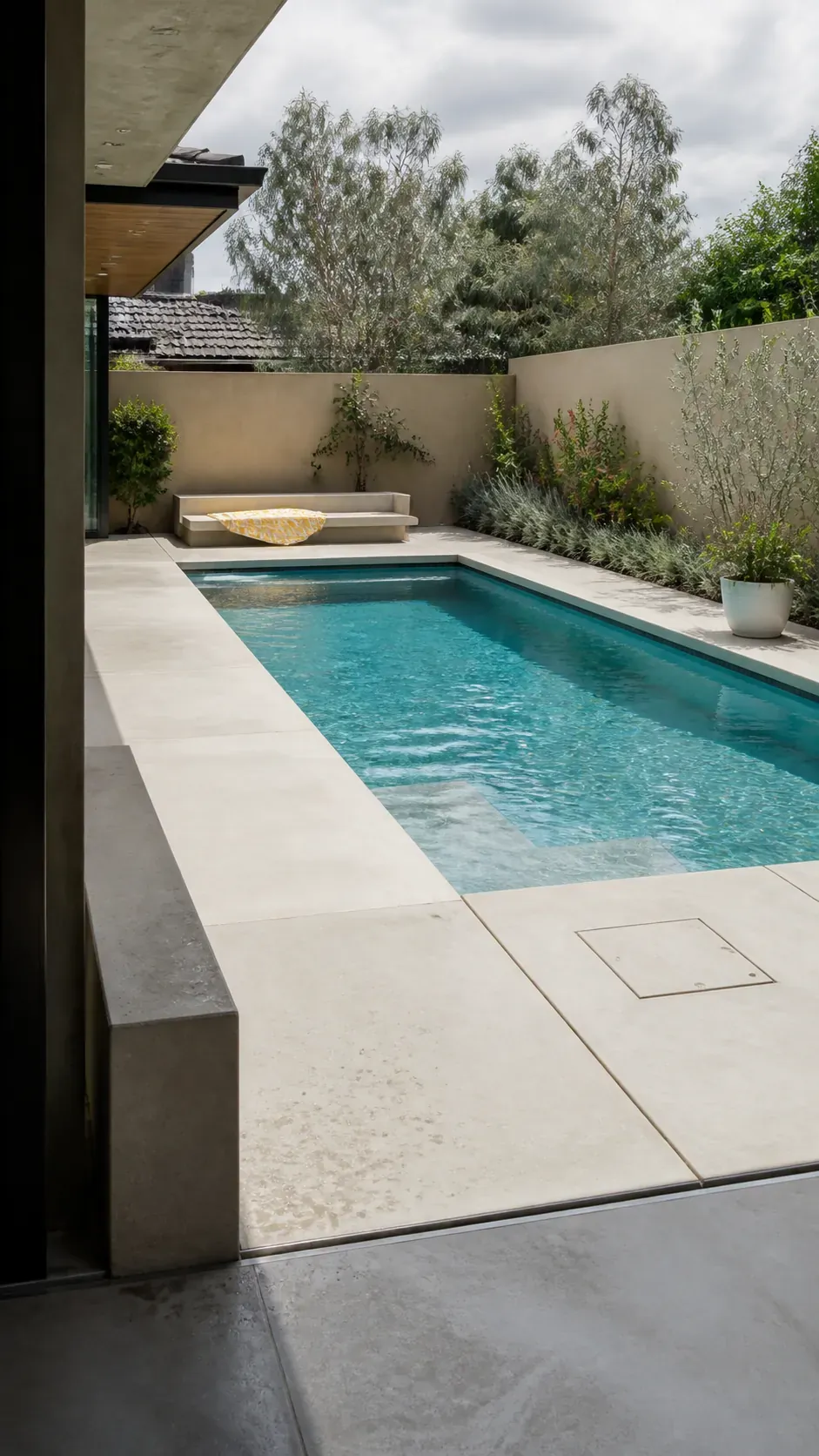 Bright minimalist pool with pale concrete coping and deck