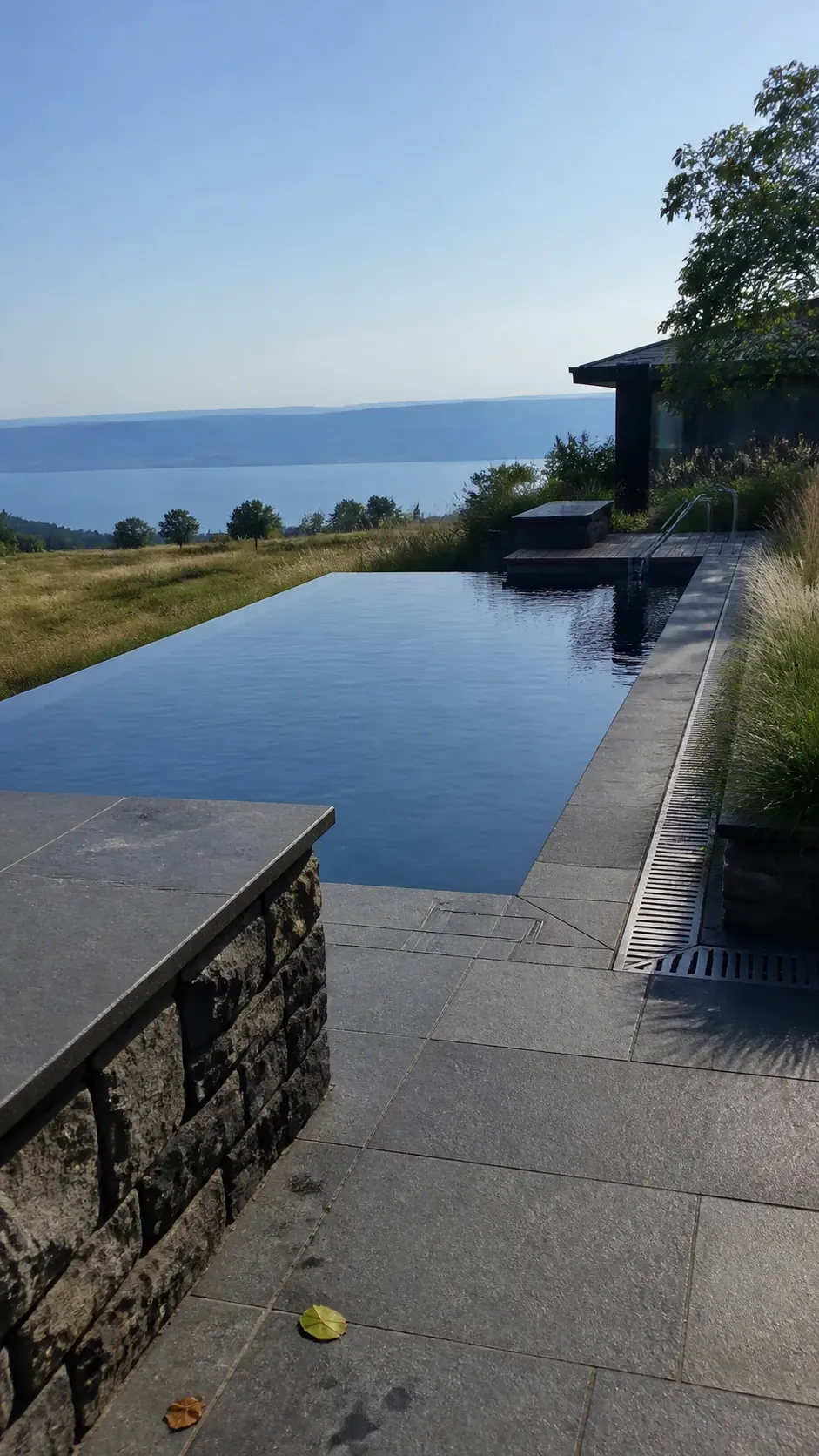 Modern infinity-edge pool aligned with an open landscape view
