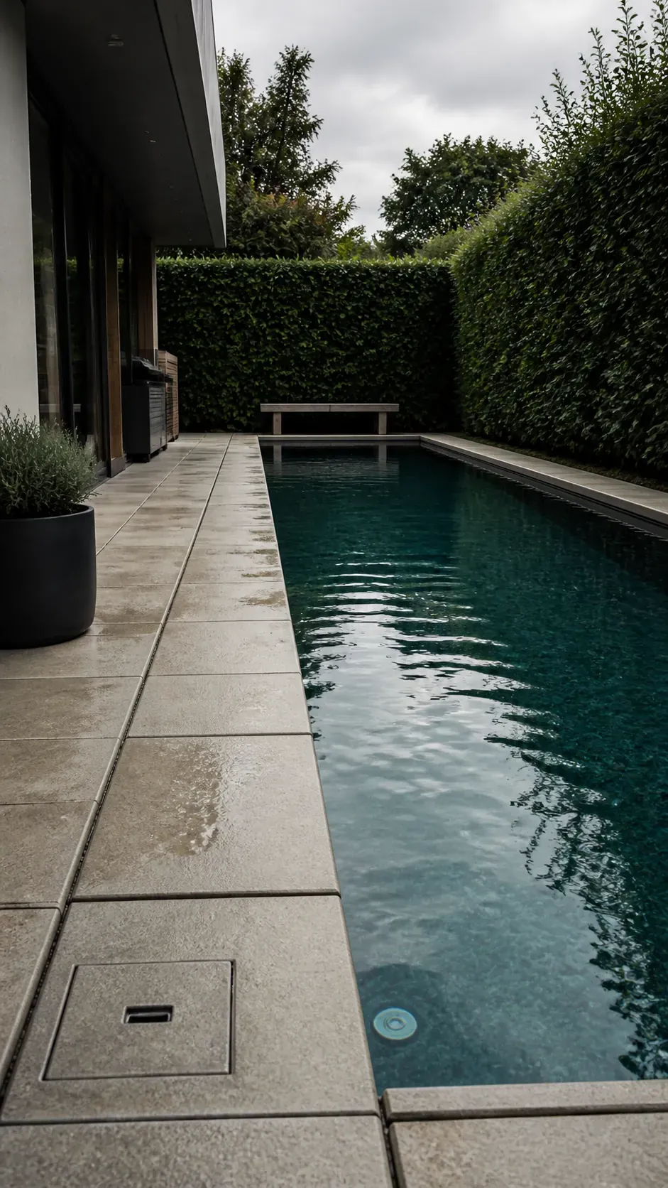 Modern pool deck with large-format pavers aligned parallel to water
