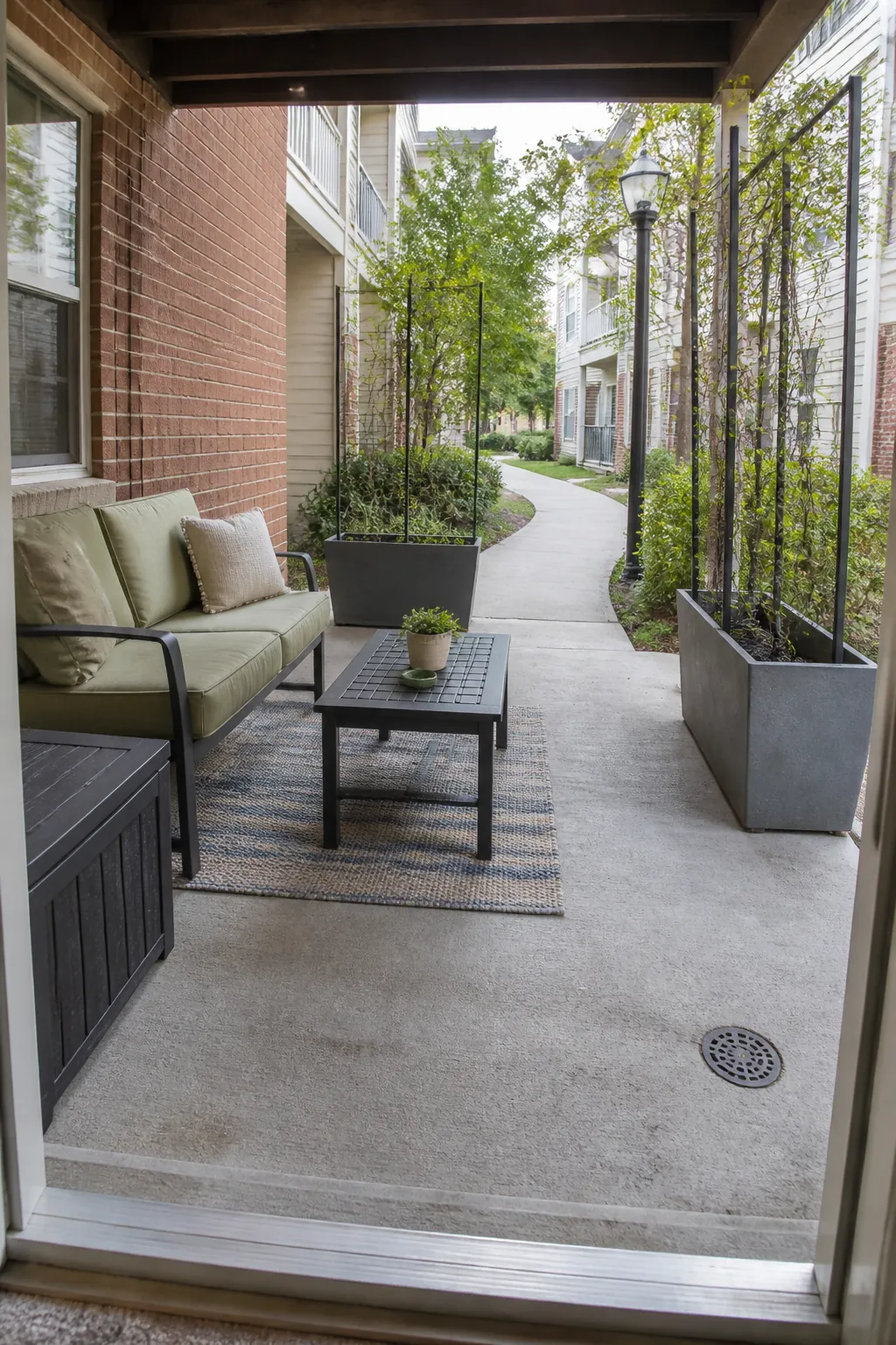 Ground-floor apartment patio with privacy, plants, seating, and a clear exit